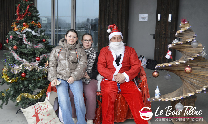 Elèves posant avec le Père-Noël entre les deux sapins